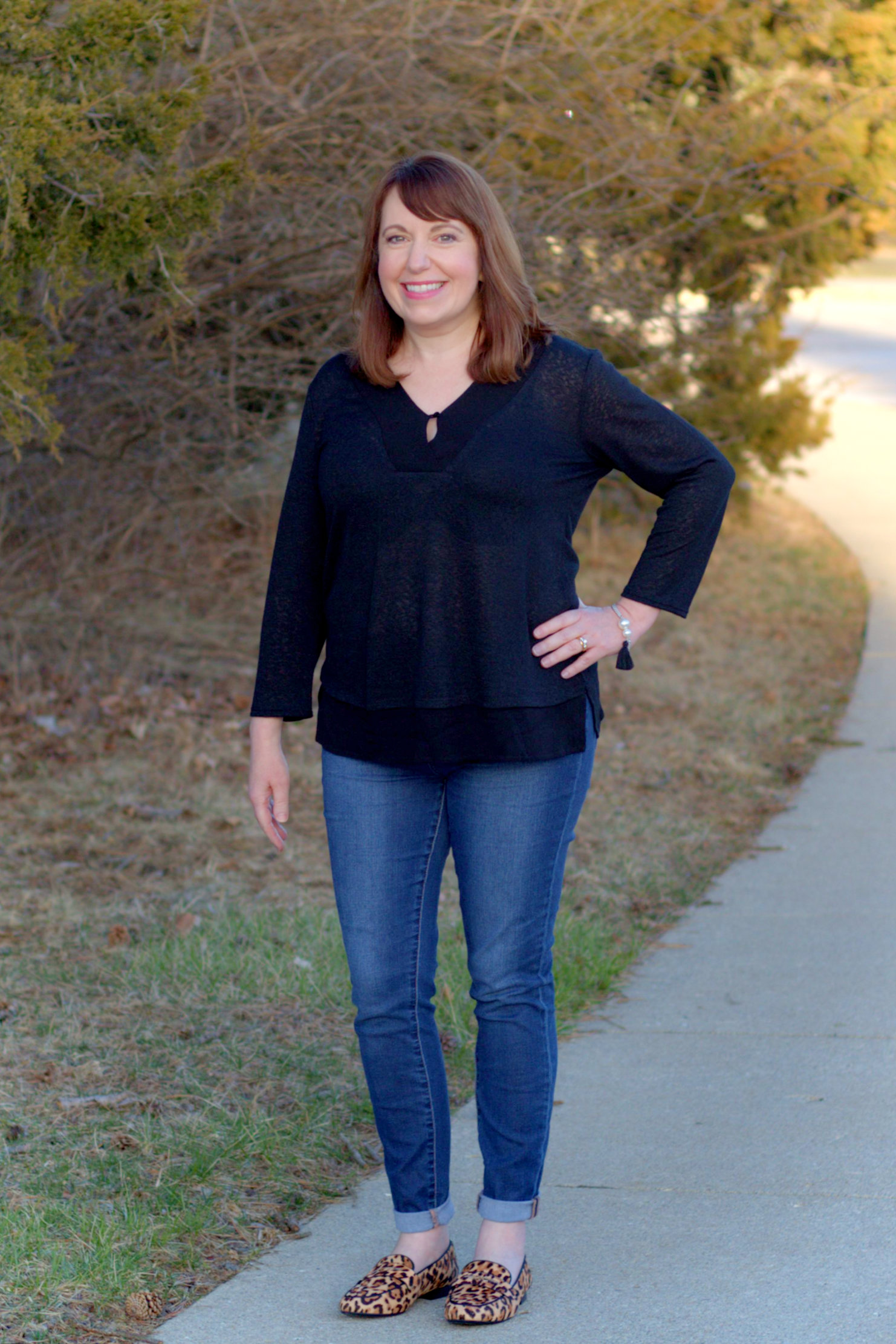 Dianna Miller Wearing A Black Top, Jeans, And Leopard Print Loafers